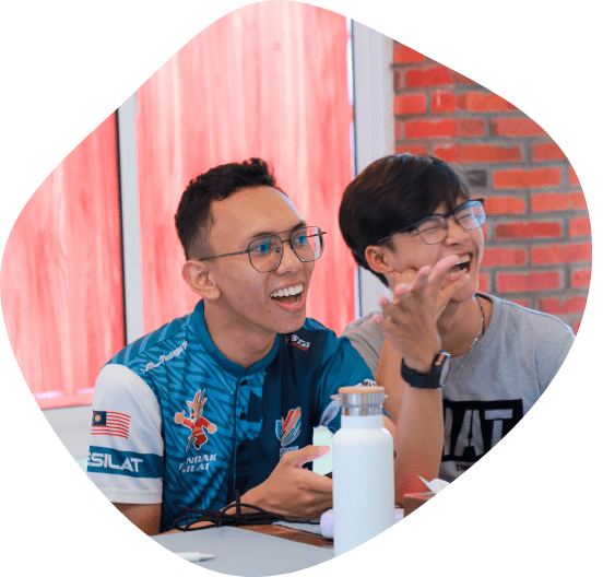 Two youths from Southeast Asia sit at a table laughing